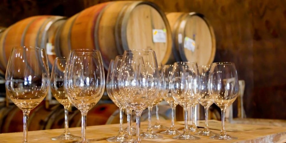 Wine Glasses in Front of Wine Barrels
