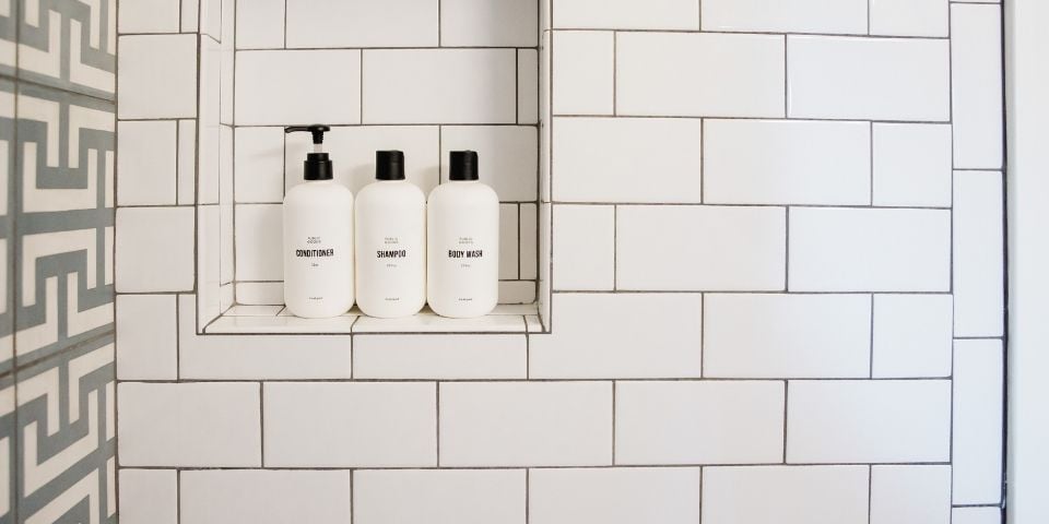 The Wall of A Bathroom Featuring Subway Tile and Shampoo and Body Wash