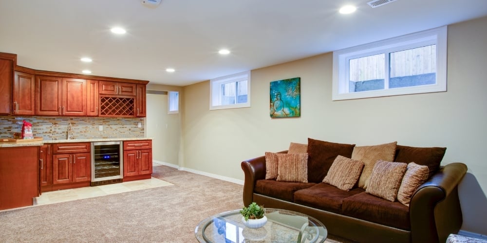 Nicely Decorated Basement With Couch and Kitchen