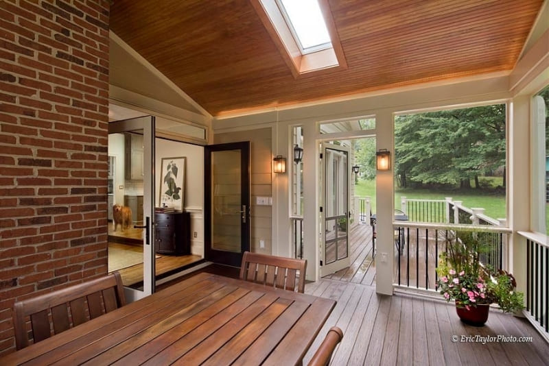 Large Enclosed Outdoor Living Area Off of Home Entered Through Modern French Doors with Beautiful Brick Accent and Wood Ceiling | Denny + Gardner Outdoor Living Space Services