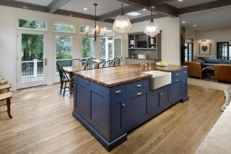 Kitchen Remodeling Services Large Eat-In Island Blue Cabinetry and Exposed Beams with Farmhouse Sink | Denny + Gardner Design-Build Remodelers