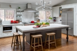 Kitchen Remodeling Services Large Eat-In Island with Modern Light Fixtures and Built-In Appliances | Denny + Gardner Design-Build Remodelers