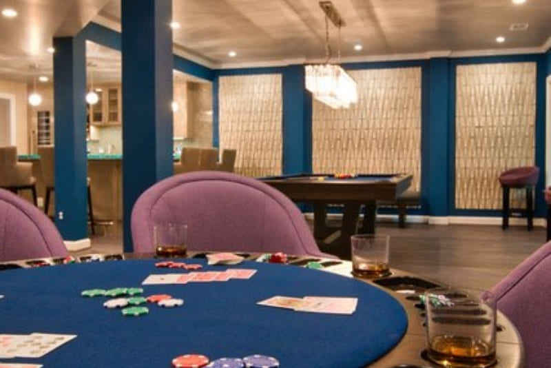 Basement Remodel Turns Basement into Vegas Style Game Room with Card Tables and Warm Chandelier Lighting | Denny + Gardner Basement Remodeling Services