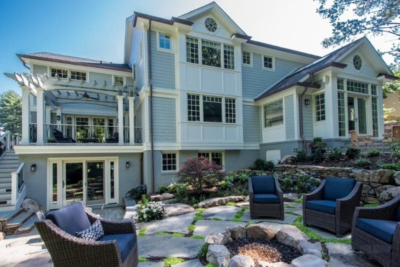 Multiple Outdoor Living Space in Large Backyard Featuring Covered Seating Areas and an Enclosed Sunroom and Pergola Areas and Fire Pit | Denny + Gardner Outdoor Living Space Services